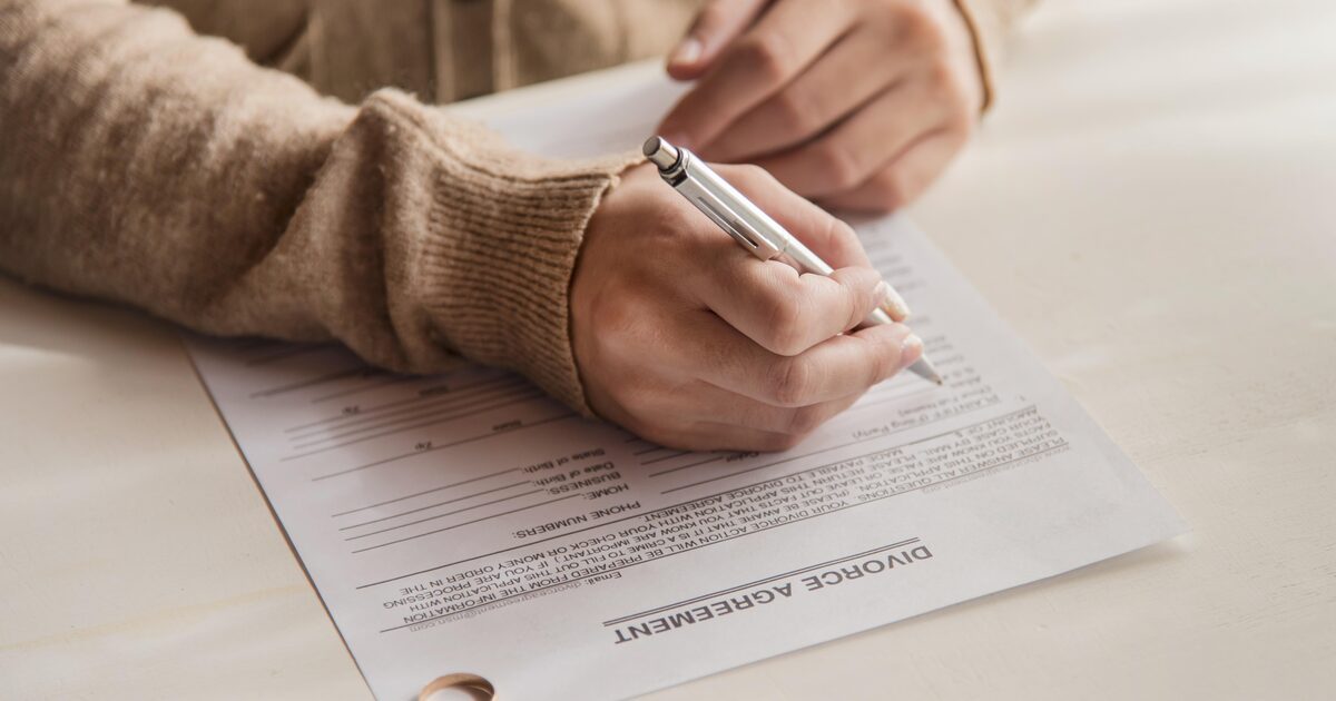 Mujer firmando un acuerdo de divorcio, trámite de divorcio en El Salvador desde EE.UU.