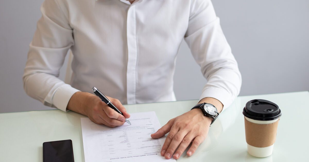 Hombre llenando un formulario para rectificar su partida de nacimiento salvadoreña